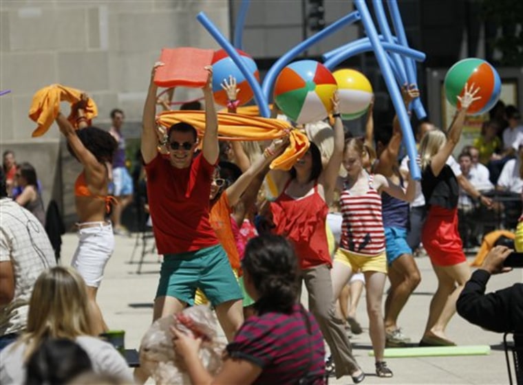 In this photo taken July 14, 2011 actors dressed in beach attire participate in a flash mob as part of a commercial for McDonald's in Chicago. Thanks to websites like Twitter and Facebook, more and more so-called flash mobs are materializing across the globe, leaving police scrambling to keep tabs on the spontaneous assemblies.(AP Photo/Charles Rex Arbogast)
